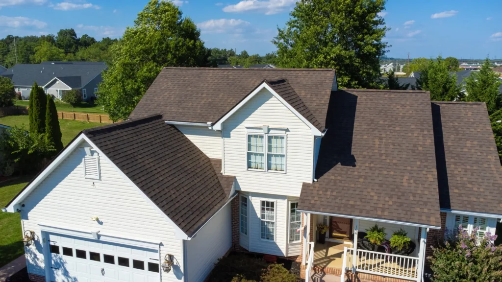 Front aerial view of a grey roof installed on a white residential home