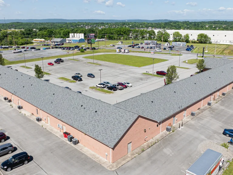 Angled aerial view of a grey roof installed on a strip commercial building
