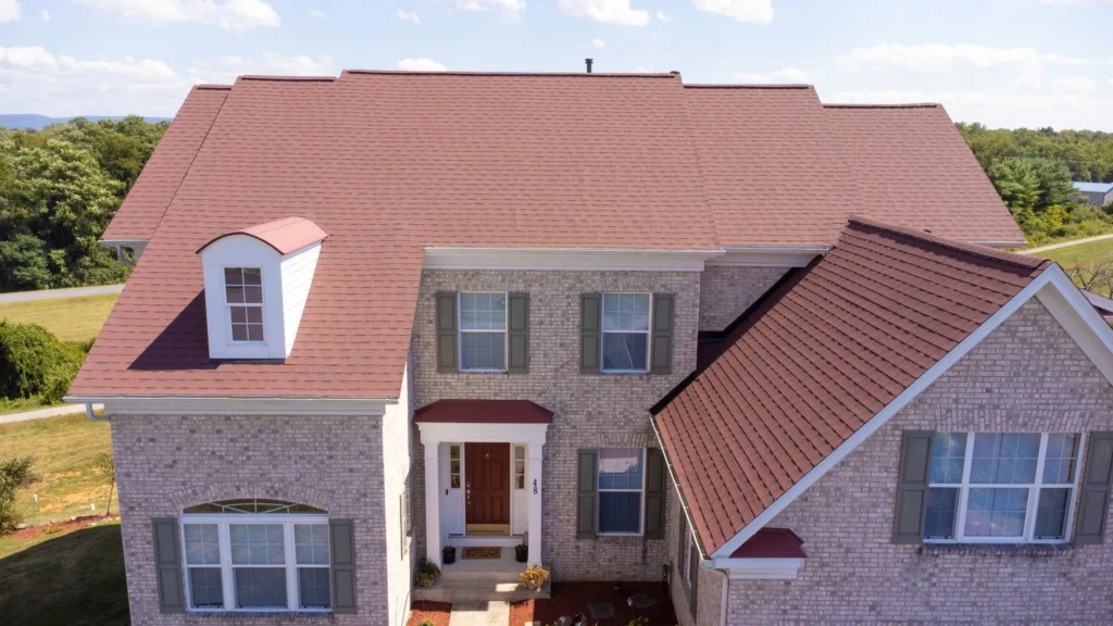 Front aerial view of a red roof installed on a brick residential home
