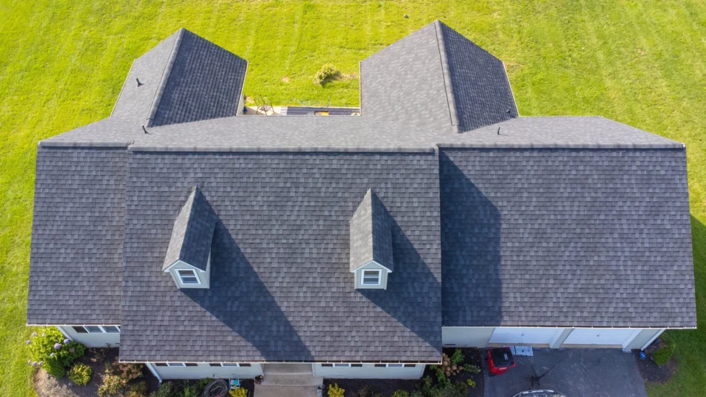 Aerial view of a gray roof installed on a white residential building