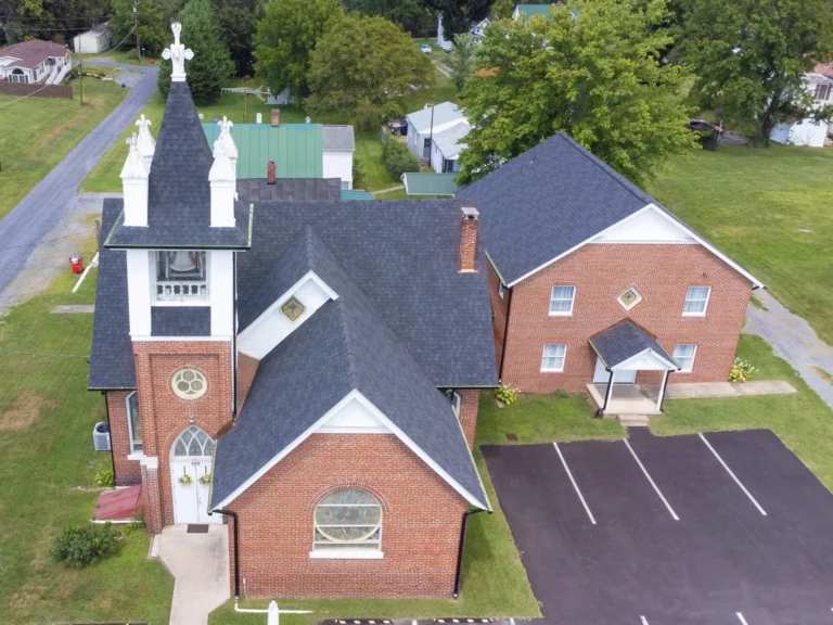 Aerial view of a grey roof installed on a brick church, featured in our gallery