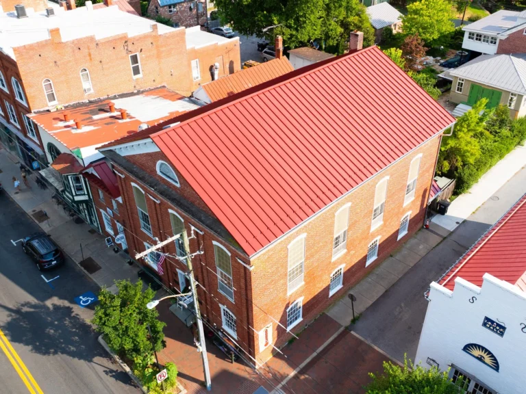 Angled view of a red metal roof on a brick commercial building, featured in our gallery