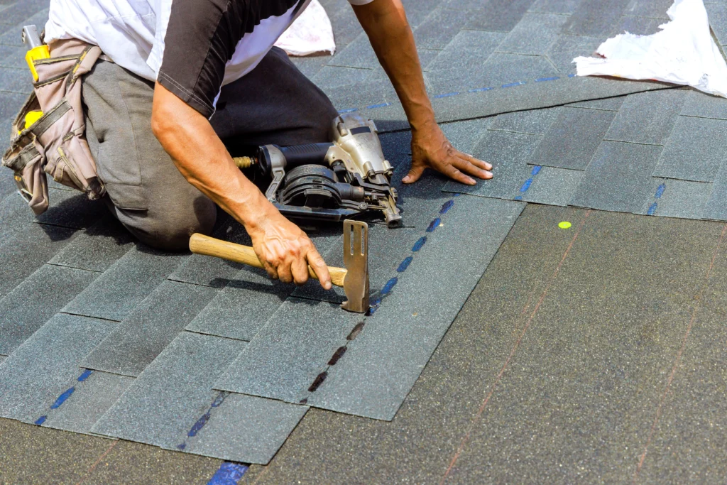 Professional roofer repairing roof panels